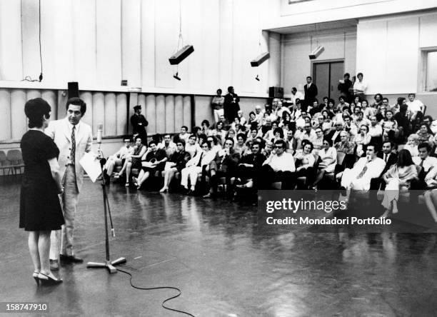 Italian TV host Corrado introducing a guest during a radio show. Rome, 1970s