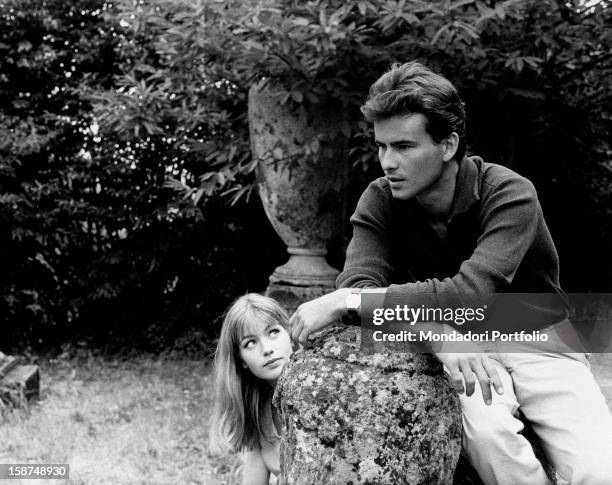 German actor Horst Buchholz sitting in a garden beside French-born Italian actress and singer Catherine Spaak. 1963