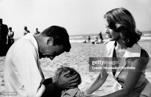 French actor Jean-Louis Trintignant is on the beach with a little girl and the Italian actress Eleonora Rossi Drago in the film Violent Summer....