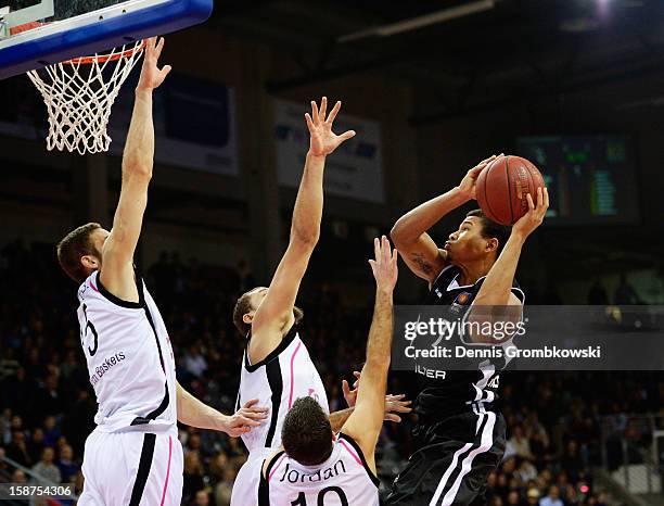 Jonas Wohlfarth-Bottermann of Bonn and teammates Kyle Weems and Jared Jordan challenge Tyrone Nash of Tuebingen during the Beko BBL Basketball...