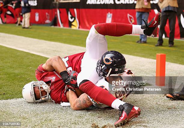 Free safety Chris Conte of the Chicago Bears and tight end Rob Housler of the Arizona Cardinals get wrapped up after an out of bounds pass during the...
