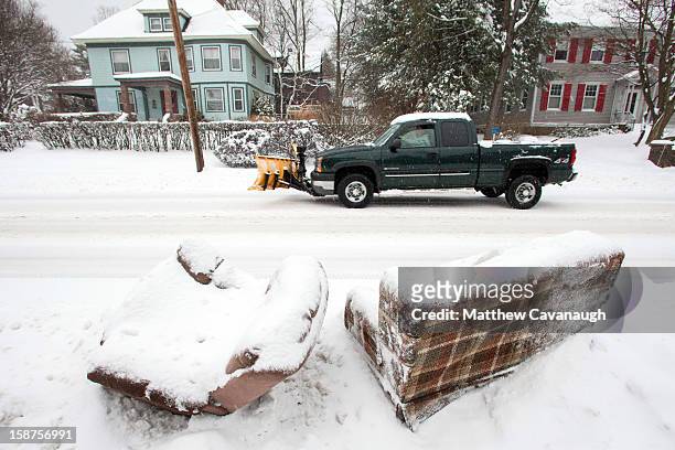 Truck drives past some discarded, snow-covered furniture on December 27, 2012 in Greenfield, Massachusetts. A serious winter storm that caused...