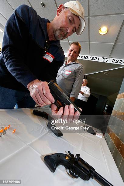 Gary Allred prepares a handgun display for teachers to learn how to handle handguns at a concealed-weapons training class to 200 Utah teachers on...