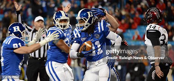 Duke Blue Devils cornerback Tony Foster is congratulated by teammates after blocking a punt by Cincinnati Bearcats punter Pat O'Donnell and...