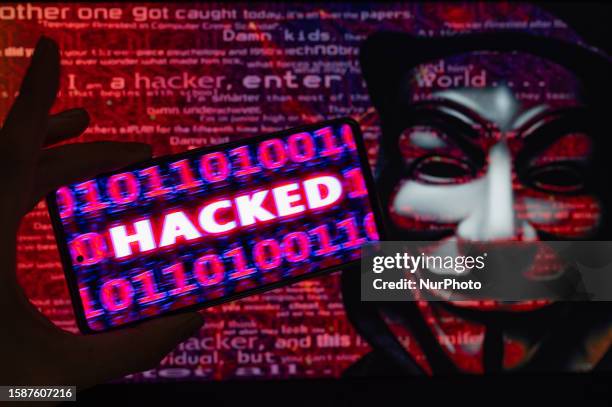 Hacked displayed on a mobile with binary code with in the background Anonymous mask. On 9 August 2023 in Brussels, Belgium. Jonathan Raa / Nurphoto