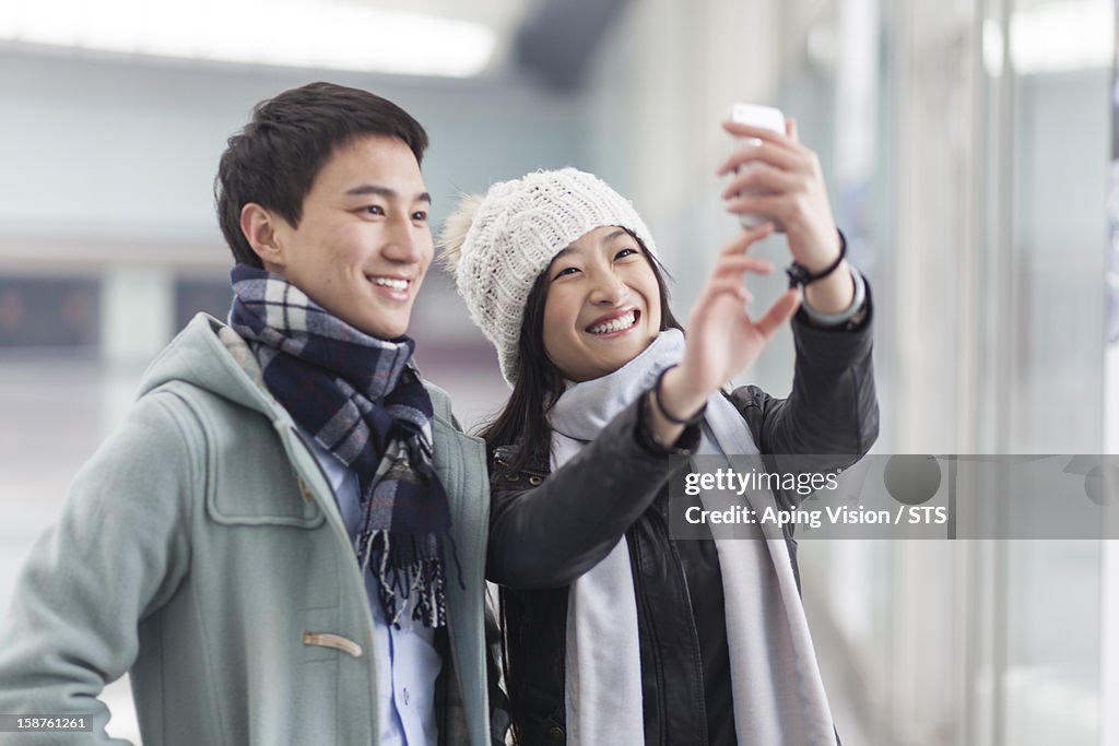 Young couple taking photo with a mobile phone