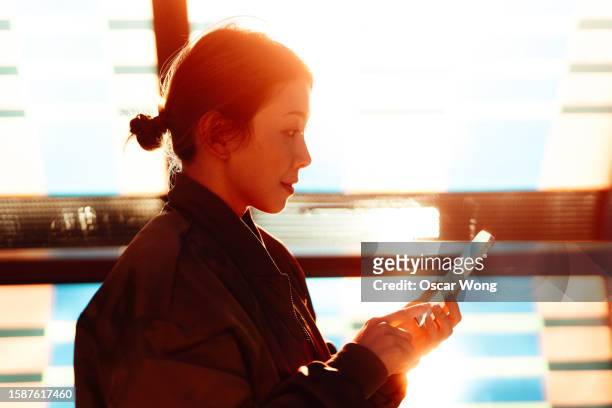 asian business woman using smartphone against sunlight - block chain stock pictures, royalty-free photos & images