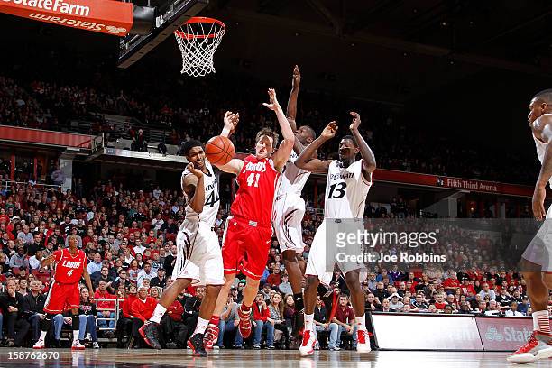 Cameron Bairstow of the New Mexico Lobos rebounds against JaQuon Parker and Cheikh Mbodj of the Cincinnati Bearcats during the game at Fifth Third...
