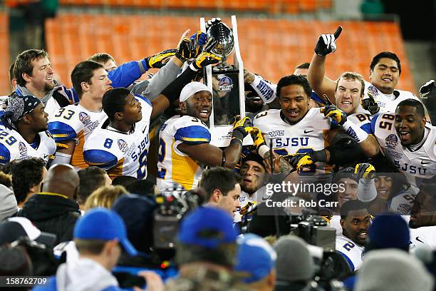 Members of the San Jose State Spartans hold up the trophy after defeating the Bowling Green Falcons 29-20 to win the Military Bowl at RFK Stadium on...