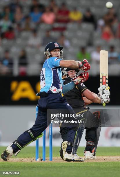 Jesse Ryder of Wellington bats as wicket keeper Gareth Hopkins of Auckland looks on during the HRV Cup Twenty20 match between the Auckland Aces and...