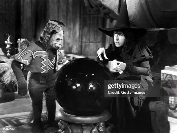 American actor Margaret Hamilton and a winged monkey look into a crystal ball in a still from the film, 'The Wizard of Oz,' directed by Victor...