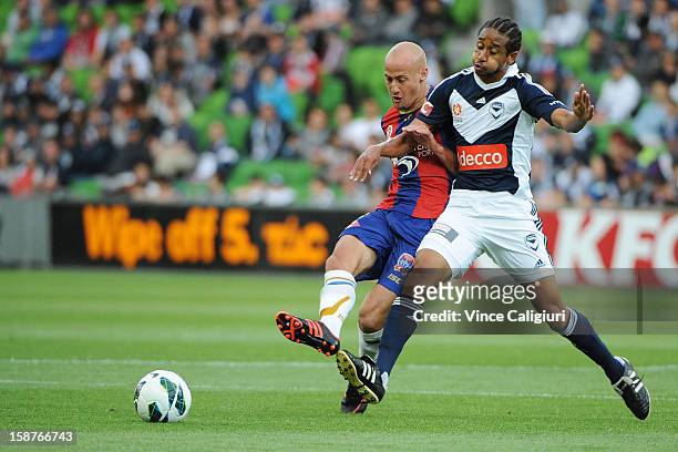 Ruben Zadkovich of the Jets is tackled by Jonathan Bru of the Victory during the round 13 A-League match between the Melbourne Victory and the...
