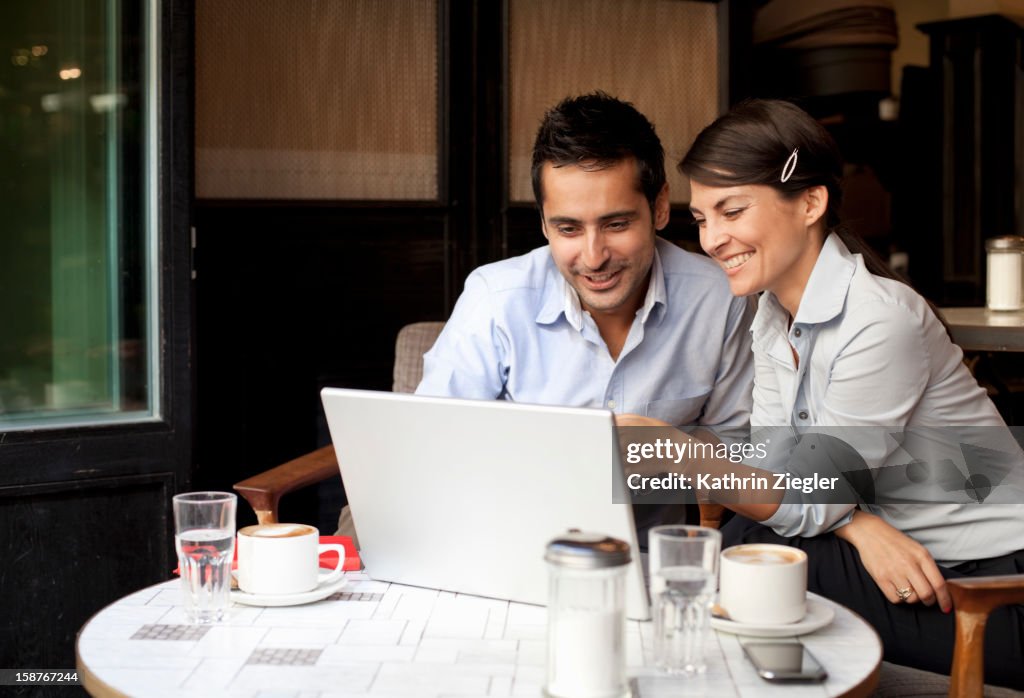 Business people working in café using laptop