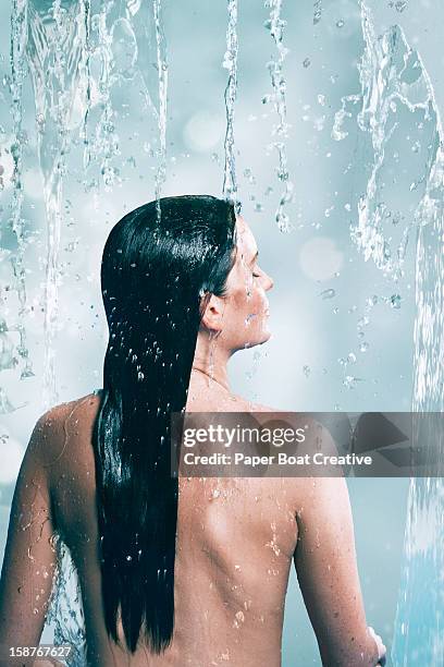 woman standing under a waterfall - boat in bath tub foto e immagini stock