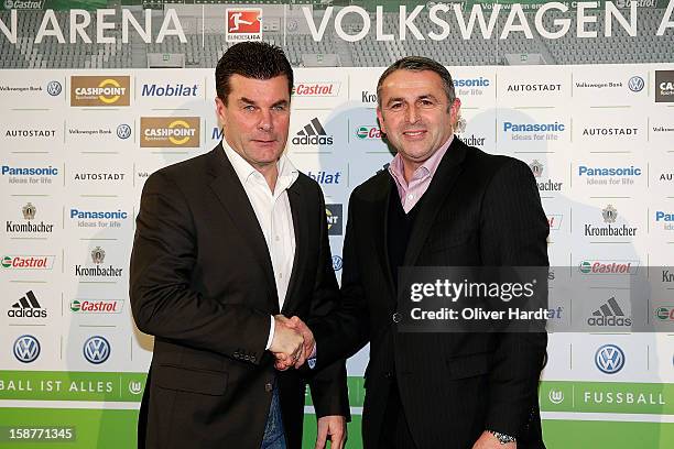 New head coach Dieter Hecking of Vfl Wolfsburg shakes hands with Sporting director Klaus Allofs during a press conference at Volkswagen Arena on...