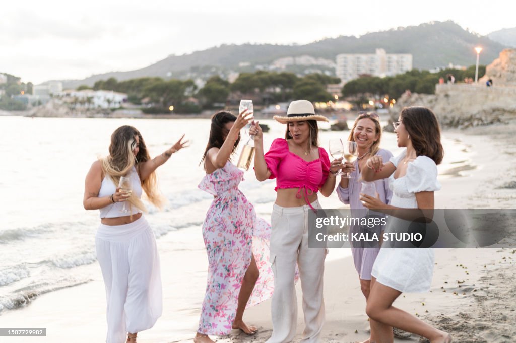 Elegant women partying and drinking on the beach