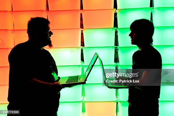 Participant hold their laptops in front of an illuminated wall at the annual Chaos Computer Club computer hackers' congress, called 29C3, on December...