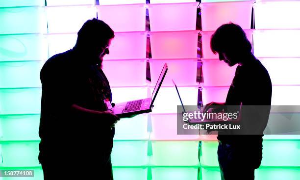 Participant hold their laptops in front of an illuminated wall at the annual Chaos Computer Club computer hackers' congress, called 29C3, on December...