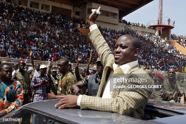 Guillaume Soro, the leader of the main rebel group in Ivory Coast waves to crowds as he arrives 04 February 2003 at the Bouake stadium for a rally,...