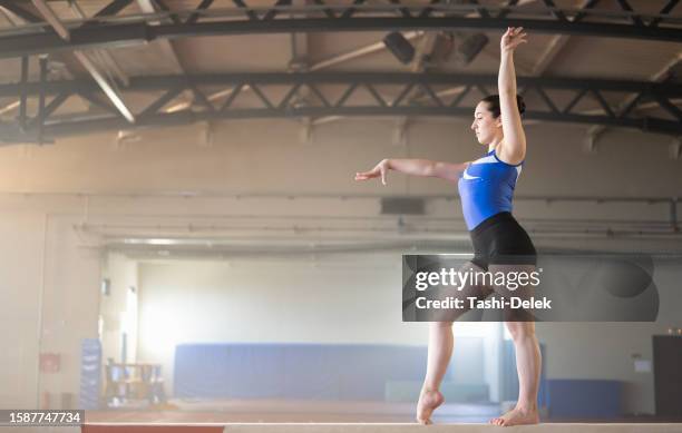 female gymnast on balance beam - acrobat stock pictures, royalty-free photos & images