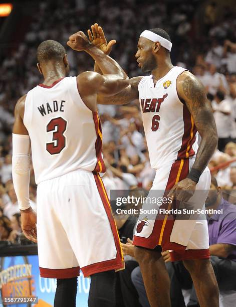 The Miami Heat's LeBron James, right, high fives teammate Dwyane Wade, after Wade dunked against the Dallas Mavericsk late in the second quarter of...