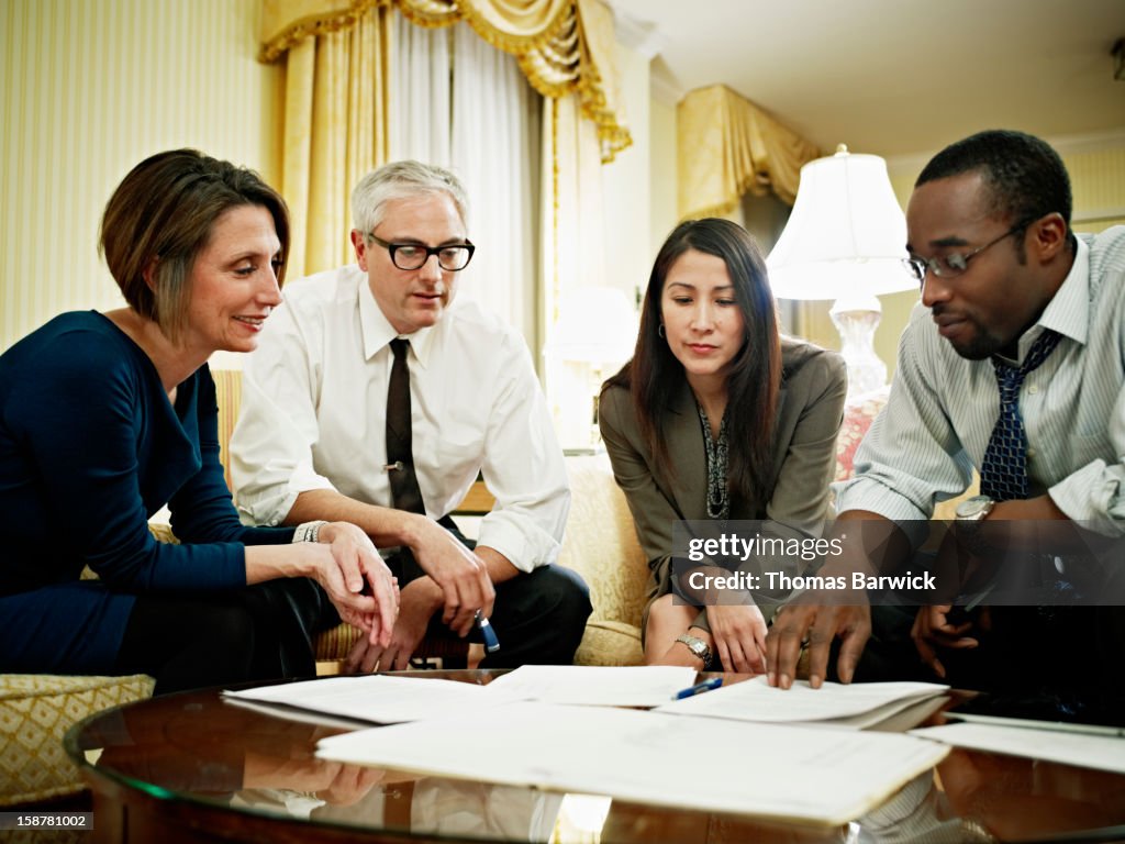 Coworkers examining project documents in hotel