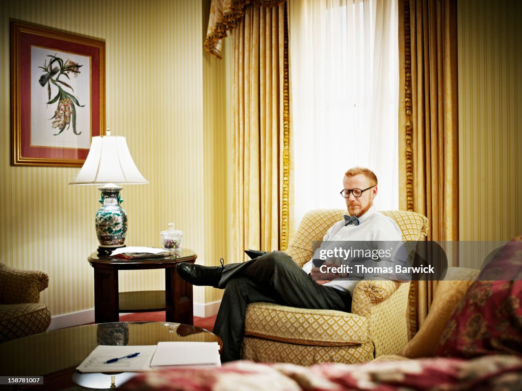 Businessman looking at smartphone in hotel room