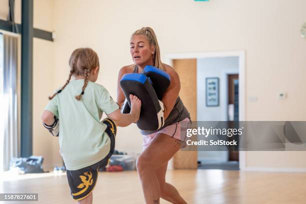 working on her high kick - martial arts instructor stock pictures, royalty-free photos & images
