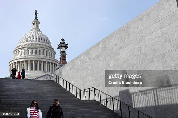 People walk down steps in front of the U.S. Capitol building in Washington, D.C., U.S., on Friday, Dec. 28, 2012. The U.S. House will hold its first...