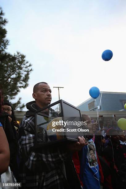 Robert Rogers, the father of 15-year-old Porshe Foster, holds a volleyball presented to him by his daughter's teammates as he waits to release a...