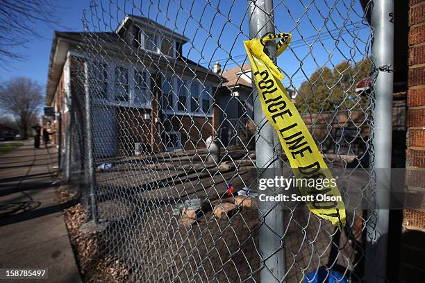 Crime scene tape hangs from a fence surrounding the backyard where 15-year-old Porshe Foster, a high school sophomore who wanted to be an architect,...