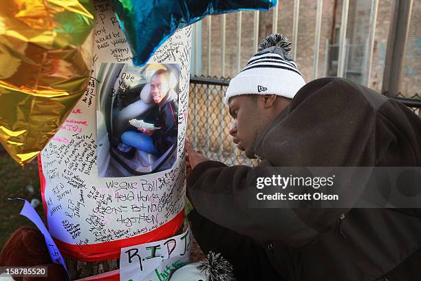 Nineteen-year-old Marcell Carter signs a memorial to his friend, 16-year-old Jeffrey Stewart in the play lot where Stewart collapsed after being shot...