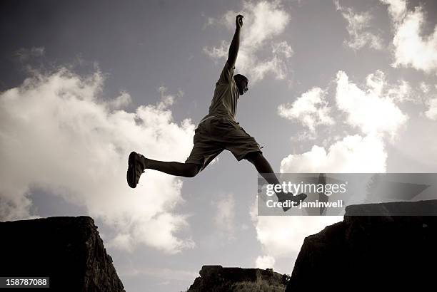 parkour free running man jumping against sky - striding stock pictures, royalty-free photos & images