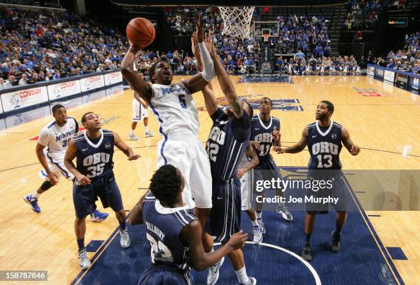 Shaq Goodwin of the Memphis Tigers drives to the basket for a layup against Mikey Manghum and Damen Bell-Holter of the Oral Roberts Golden Eagles on...