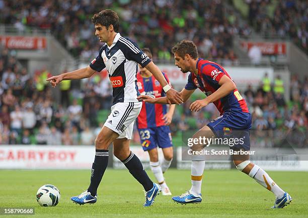 Guilherme Finkler of the Victory and Josh Mitchell of the Jets compete for the ball during the round 13 A-League match between the Melbourne Victory...
