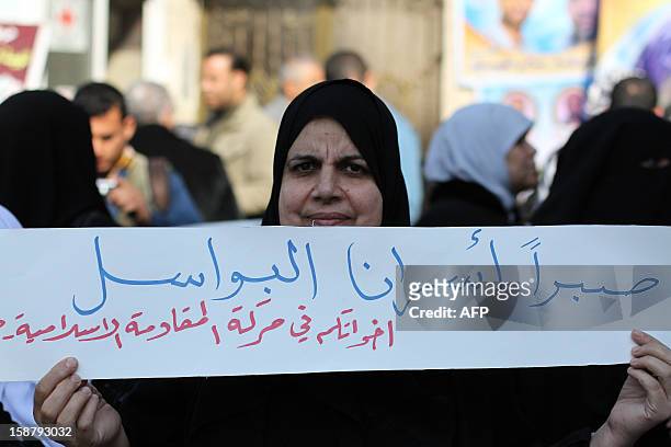 Palestinian woman holds a banner reading in Arabic: "Patience our noble prisoners" during a sit-in demonstration in support of Palestinian prisoners...