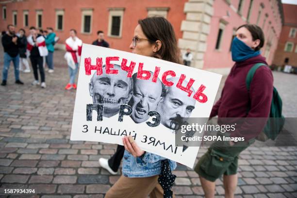 Belarusian woman holds a placard with the caricature images of Putin, Prigozhin and Lukashenko during the march in Warsaw. Hundreds of Belarusians...