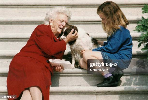 This file photo shows former First Lady Barbara Bush talking to her dog Millie as she and grandaughter Barbara Bush, age nine, wait for US President...