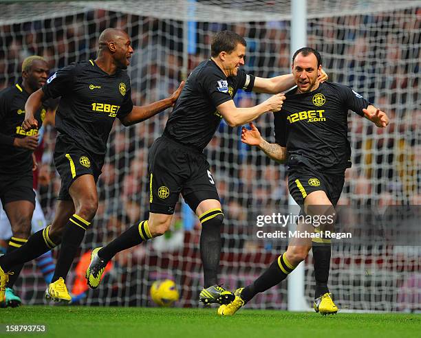 Ivan Ramis of Wigan celebrates scoring to make it 1-0 with team mates Gary Caldwell and Emmerson Boyce during the Barclays Premier League match...