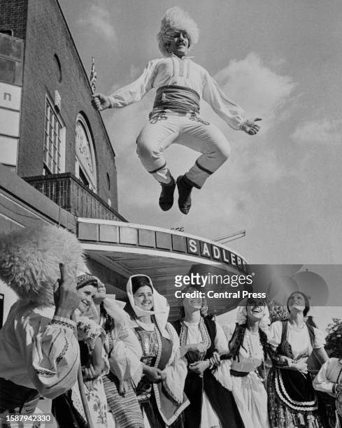 Yugoslavian dancer Gavrilovic Radoslav of the 26-strong Yugoslavian dance company Opanak, leaping mid-air above other dancers, all in traditional...