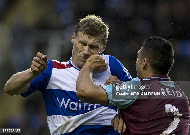 Reading's Russian striker Pavel Pogrebnyak collides with West Ham United's New Zealand defender Winston Reid during the English Premier League...