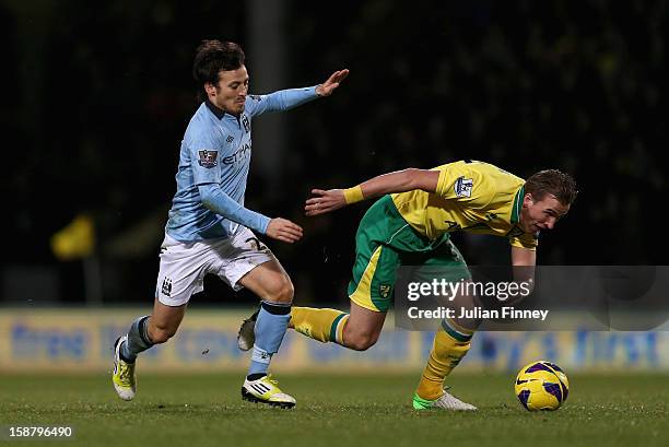 David Silva of Manchester City and Harry Kane of Norwich City tussle for the ball during the Barclays Premier League match between Norwich City and...