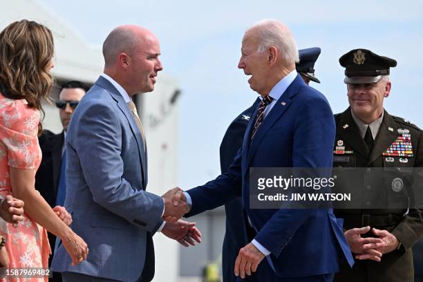 President Joe Biden shakes hands with Utah Governor Spencer Cox upon arrival at Roland R. Wright International Guard Base in Salt Lake City, Utah, on...