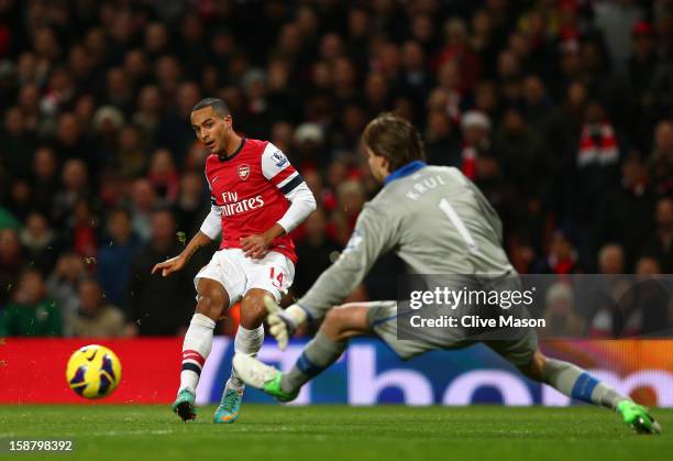 Theo Walcott of Arsenal scores the first goal past Tim Krul of Newcastle United during the Barclays Premier League match between Arsenal and...
