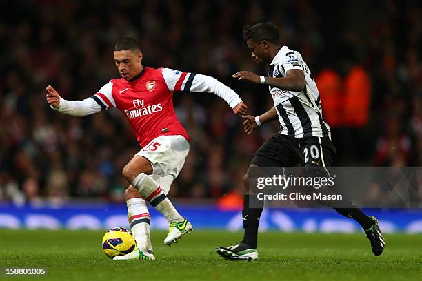 Alex Oxlade-Chamberlain of Arsenal is put under pressure by Gael Bigirimana of Newcastle United during the Barclays Premier League match between...