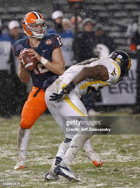 Ryan Nassib of the Syracuse Orange looks for an open man against the West Virginia Mountaineers in the New Era Pinstripe Bowl at Yankee Stadium on...