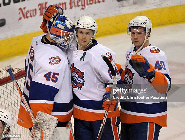 Anders Nilsson of the Bridgeport Sound Tigers is congratulated by David Ullstrom and Mike Halmo after defeating the Manchester Monarchs during an...