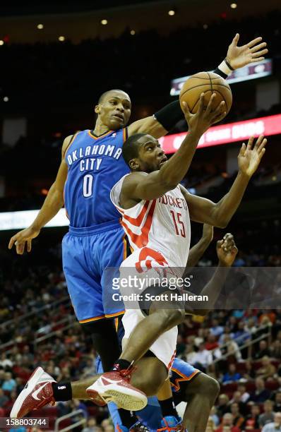 Toney Douglas of the Houston Rockets takes a shot against Russell Westbrook of the Oklahoma City Thunder at the Toyota Center on December 29, 2012 in...