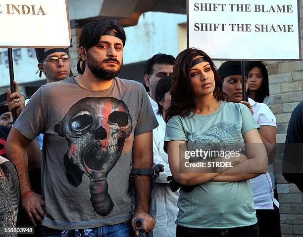 Indian Bollywood actress Sonali Bendre and her husband Goldie Behl take part in a candlelight vigil in Mumbai on December 29 after the death of a...