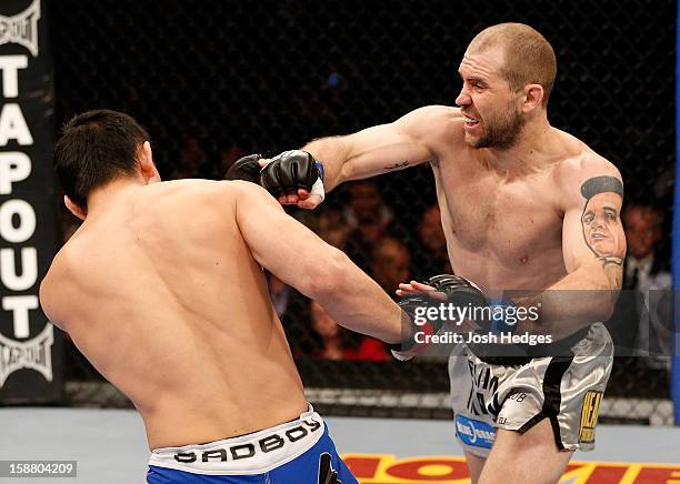 Alan Belcher punches Yushin Okami during their middleweight fight at UFC 155 on December 29, 2012 at MGM Grand Garden Arena in Las Vegas, Nevada.